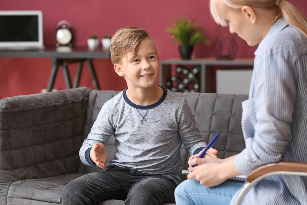 Child smiling while speaking with an educational and school psychologist